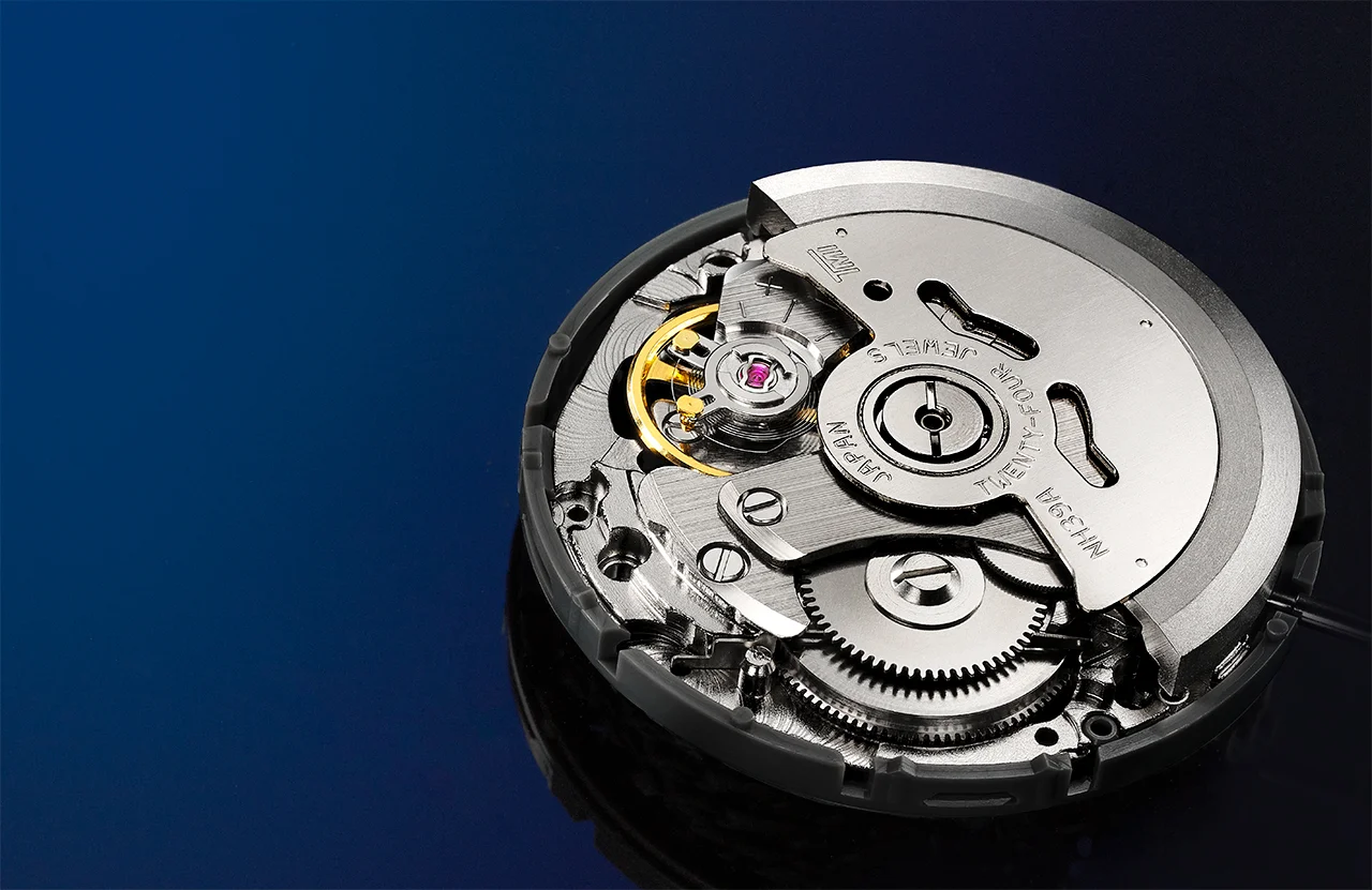 Time Module Limited NH39A automatic watch movement with rotor, gold balance wheel and ruby jewel on deep blue background, macro photography Hong Kong